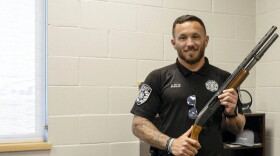 Kingfisher County Sheriff Aaron Pitts stands in his office with the gun initially labeled as missing in an audit by the State Auditor's Office.