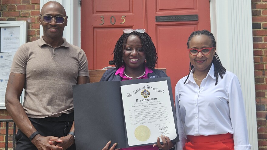 Dion Banks and Kisha Petticolas stand with Mayor Lajan Cephas Bey in tribute to Liberia's independence day