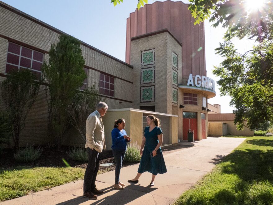 From left, Kansas Legal Services executive director Matt Keenan, Mariana Villegas, and KLS staff attorney Katie King speak after a court hearing on May 12, 2026, outside of the Agricultural Hall, which sits in the shadow of the Stormont Vail Events Center in Topeka.