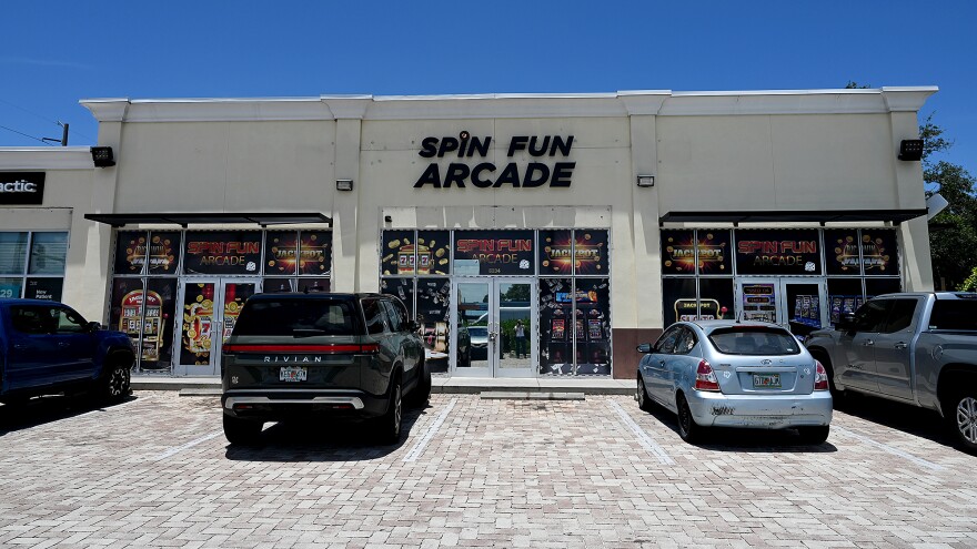 White building with cars parked in front, sign says Spin Fun Arcade