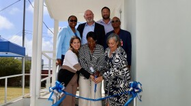 Pictured: Tropical Shipping representatives cut the ribbon to their new administrative and warehouse facility, joined by contractor James Benton, pictured in the back row.