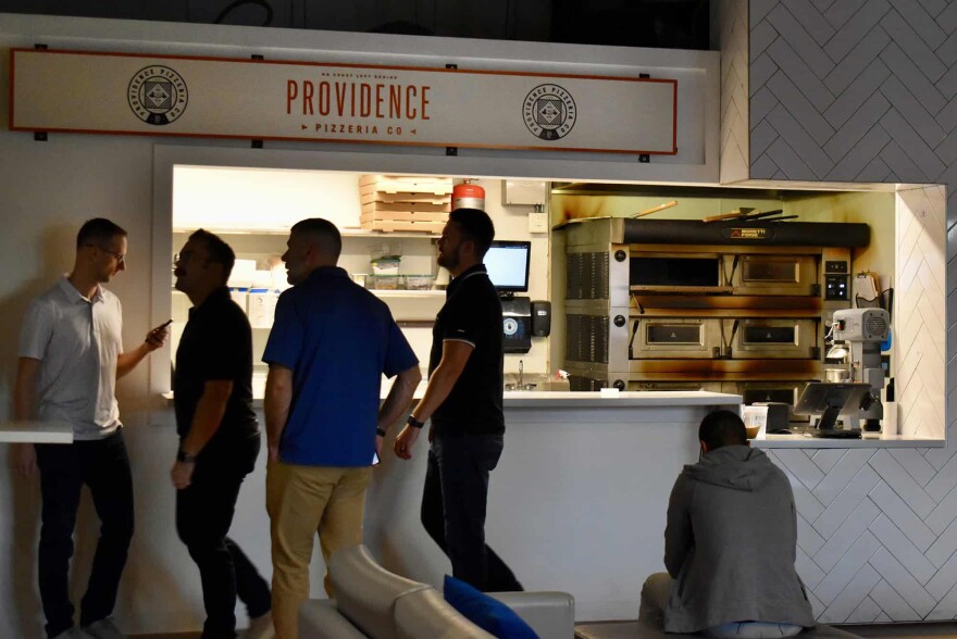 Diners walk past Providence Pizza inside Parlor KC.
