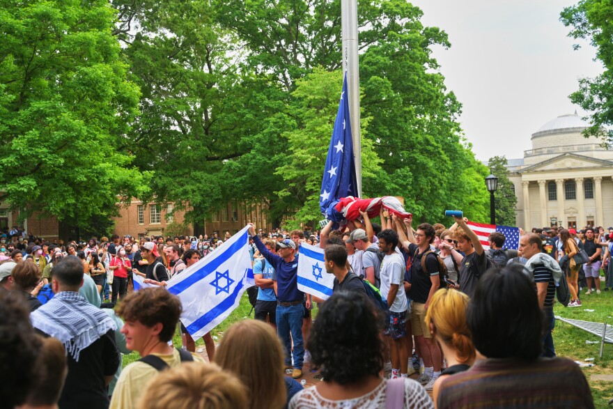 Students — mostly young men who belong to UNC-Chapel Hill fraternities — hold up the U.S. flag after it was removed by protestors and replaced with a Palestinian one on Tuesday, April 30, 2024.