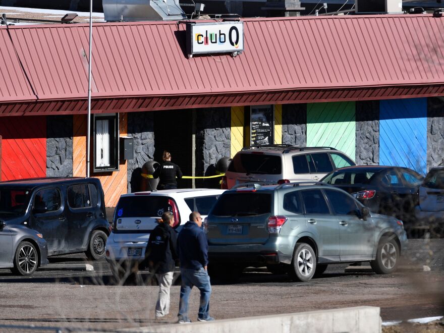 Law enforcement officers walk through the parking lot of Club Q, an LGBTQ nightclub, in Colorado Springs, Colo., on Sunday.