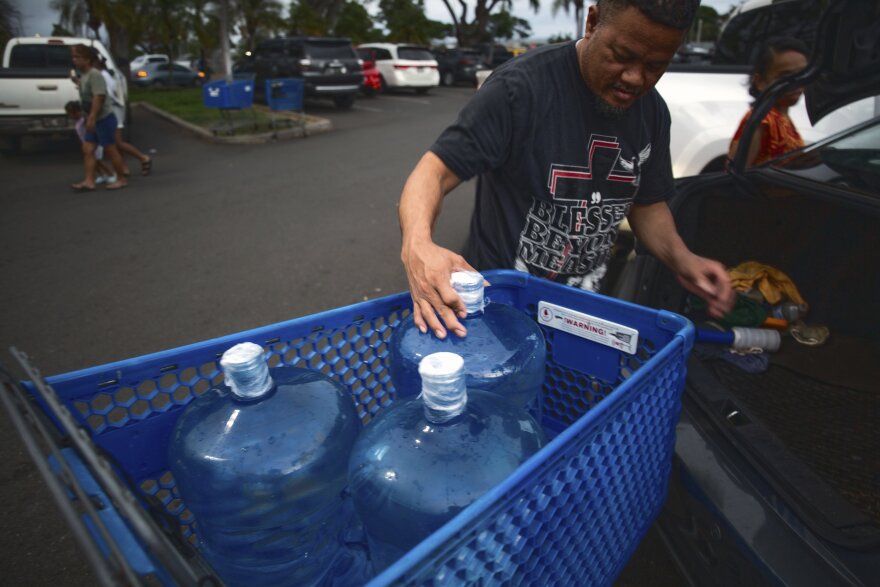 Washington state resident Poppy Mellon fills his car with jugs of water in preparation for the tsunami threat at the Kapolei Walmart, Hawaiʻi, Tuesday, July 29, 2025.