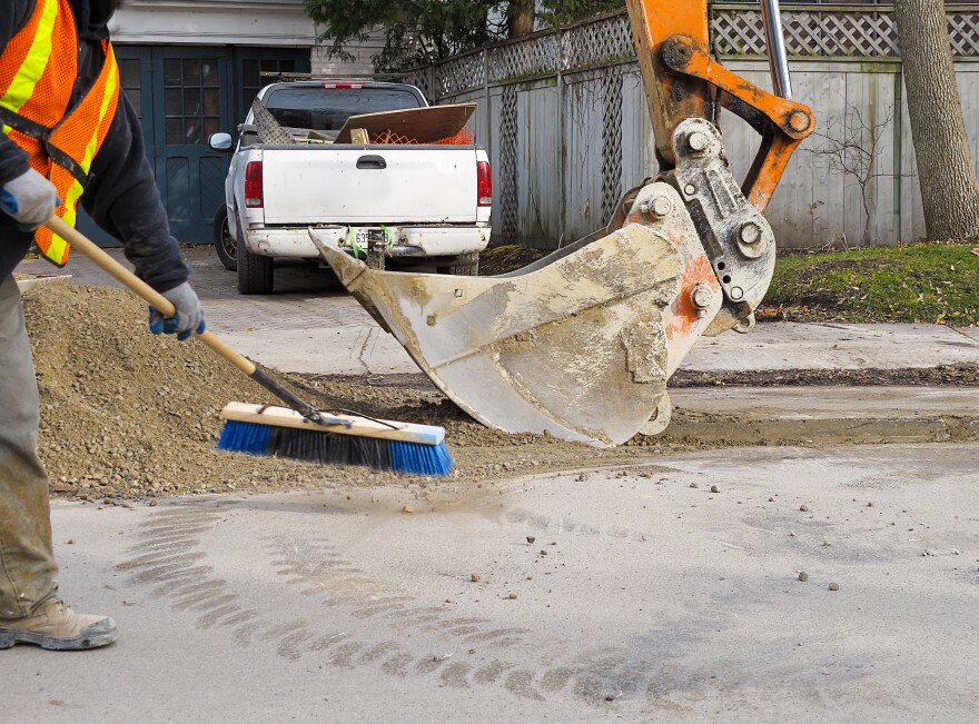 Backhoe and gravel used to upgrade road surface