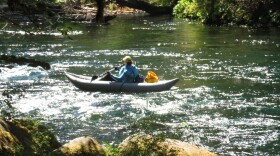 A kayaker floats down the McKenzie River, which has been deemed hazardous due to fallen trees and debris from the Knoll Fire recently. 