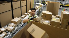 FILE - In this Nov. 11, 2010 file photo, Ricardo Sandoval sorts packages at an Amazon.com fulfillment center, in Phoenix. Merchants are working hard to make same-day delivery a reality, particularly in major cities, from Amazon testing deliveries via taxis to everyone from Target to Google expanding their same-day delivery services. (AP Photo/Ross D. Franklin, File)