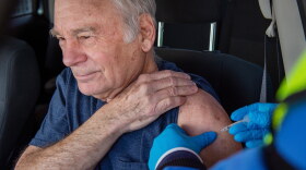 Alan Miller, 78, of Marlborough, receives the first dose of the Pfizer vaccine from Valerie Faiella, RN, at Connecticut’s largest drive-through vaccination clinic administered by Community Health Center, Inc, at Pratt & Whitney Runway in East Hartford.