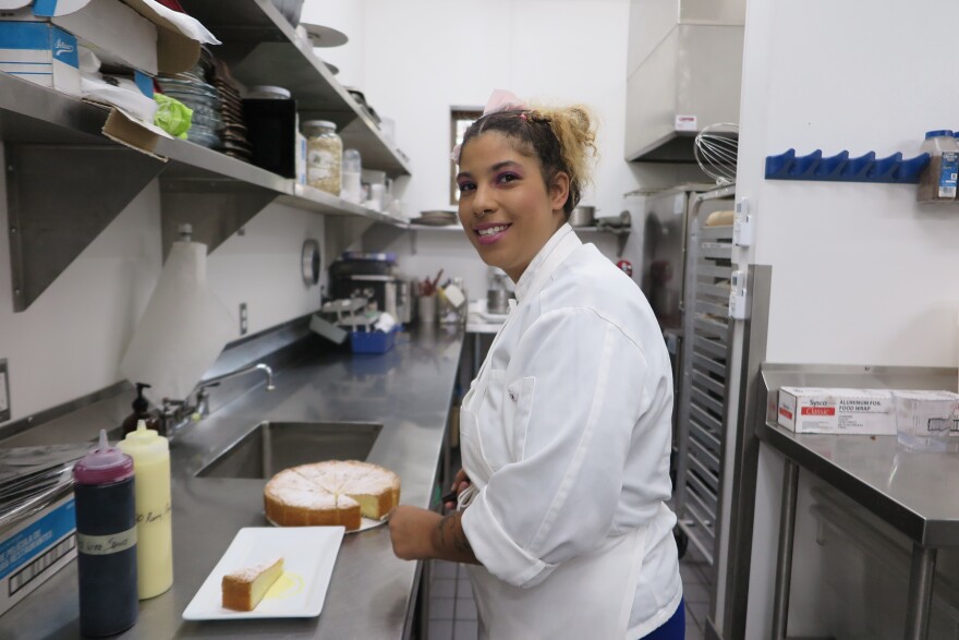 Assistant Pastry Chef Brittany Buchner shows off a slice of her Basque Cake, a yellow cake that needs be perfectly filled with pastry cream to hold its shape.