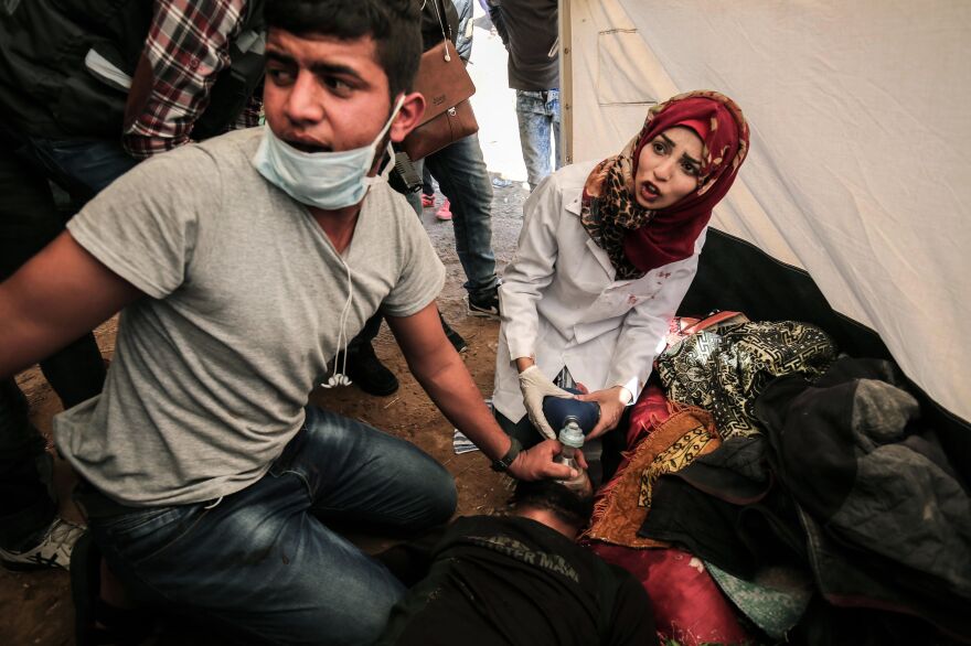 Medical staff help an injured Palestinian man at an emergency medical tent after clashes with Israeli security forces following a demonstration near the border with Israel in the southern Gaza Strip, on April 1.