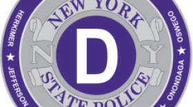 Purple and gray circular emblem of the New York State Police Department, Troop D, covering Herkimer, Jefferson, Lewis, Madison, Oneida, Onondaga, and Oswego Counties