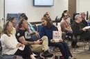 A woman holds a "No Data Centers" sign in the crowd at a city council meeting