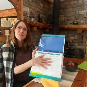 Julie Cordier, who estimates she's visited between 15 and 20 different people in ICE detention over the past few months, at the detention center just 20 minutes from her home. IPR has blurred the photo where personal information appears on the sheet. (Photo: Claire Keenan-Kurgan/IPR)