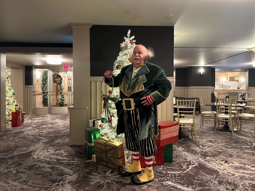A man dressed as Mr. Jingeling smiles and jingles a set of keys.