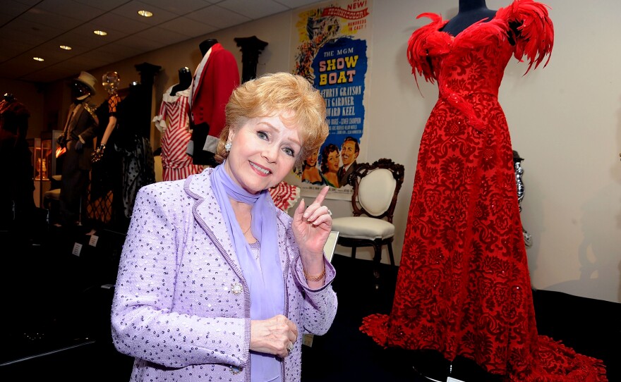 Debbie Reynolds poses with a costume she wore in <em>The Unsinkable Molly Brown</em> at The Paley Center for Media's Reception for "Debbie Reynolds: The Exhibit" in 2011 in Beverly Hills, Calif.