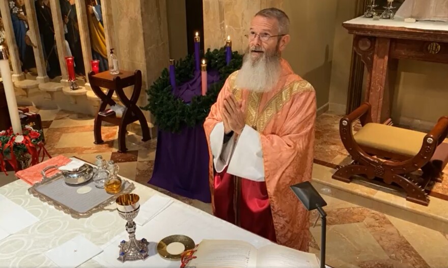 priest holding communion