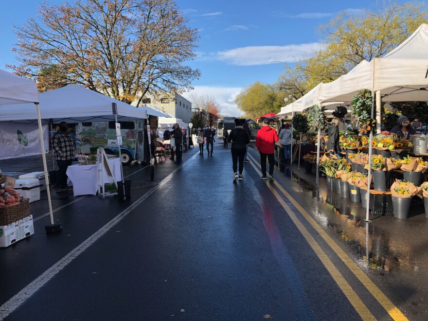 Shoppers enjoy a break in the showers at a recent Lane County Farmers Market.