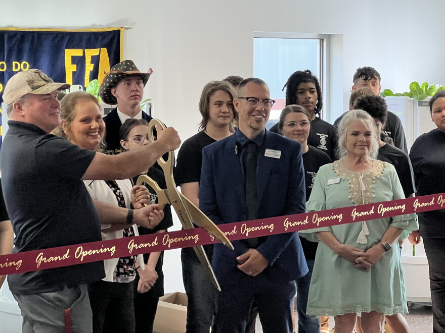 Ag instructor Tim Garmon and West Ohio Food Bank executive director Tommie Harner cut a ribbon to celebrate the food banks' partnership with the school.
