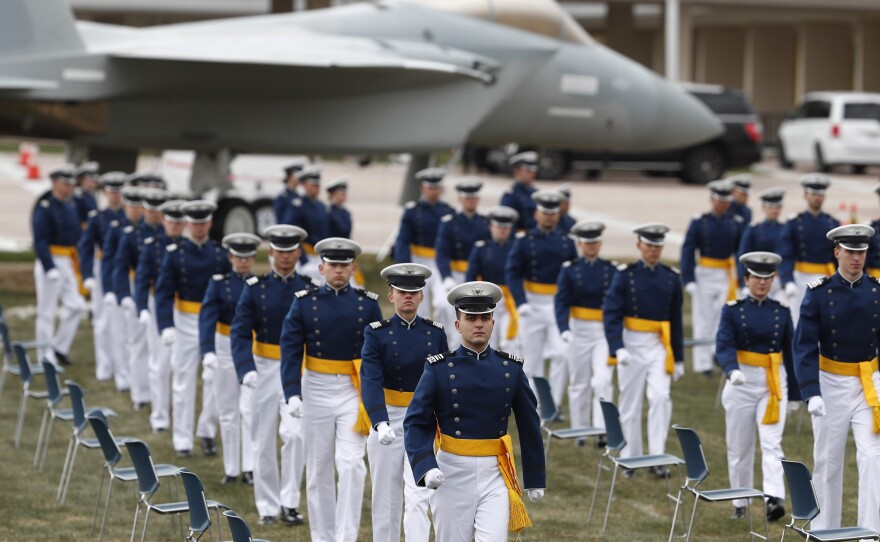 Cadets practicing social distancing march to their seats to start the graduation ceremony at the U.S. Air Force Academy.