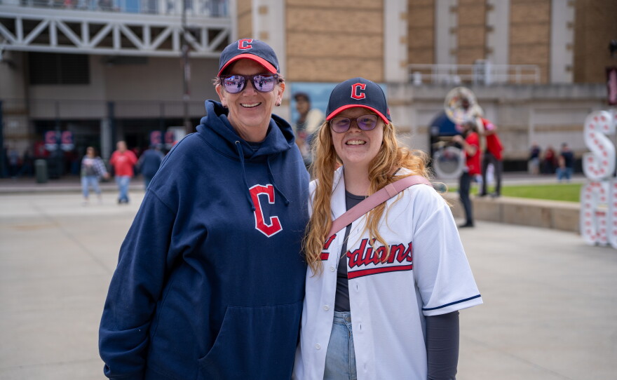 A mother and daughter in Cleveland Guardians gear smiles outside the stadium.