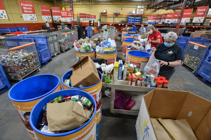 Volunteers at Harvesters sort donated food inside the organization's warehouse last year.