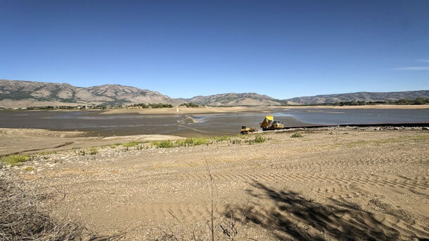 Crews haul rocks to build a temporary road across Pineview Reservoir, Sept. 14, 2026.