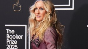 a woman in an evening gown poses on a red carpet