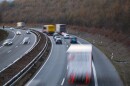 a blurry photo of cars and semi trucks in motion on a two-lane highway