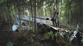 Jason Allard views an abandoned plane in the woods during a recent search.