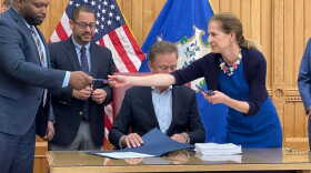 On June 22, Lt. Gov. Susan Bysiewicz hands one of the pens used by Gov. Ned Lamont to Sen. Gary Winfield, left, and Rep. Jason Rojas. They led the working group that produced the final version of the legalization bill.