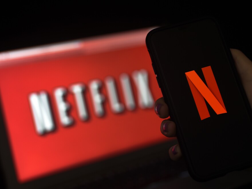 The Netflix logo is shown in this photo illustration of a computer screen and mobile phone display on March 31, 2020 in Arlington, Va. Streaming sites such as Netflix have surged in popularity during the pandemic.