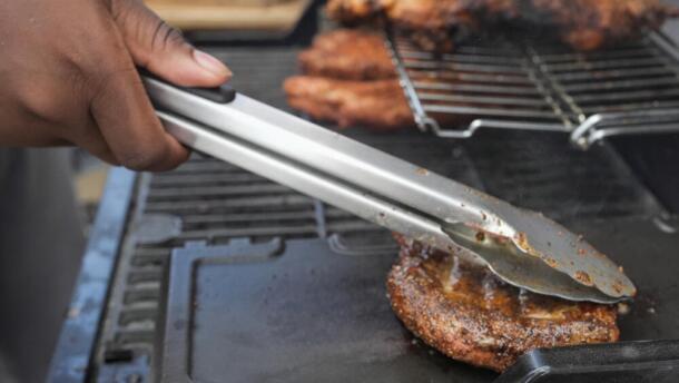 Eric Farley, of the Boys and Girls Club, sears a piece of grilled pork at the World Championship Barbecue Cooking Contest, Friday, May 17, 2024, in Memphis, Tenn. (George Walker IV/AP)
