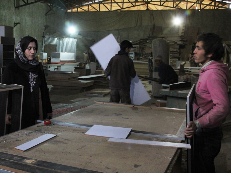 Fatima Jafari, owner of Bamboo Wood Industries, listens to a worker in her factory in Kabul, Afghanistan. Jafari is one of the few female entrepreneurs in an industrial trade in the country, despite international efforts to support women in business.