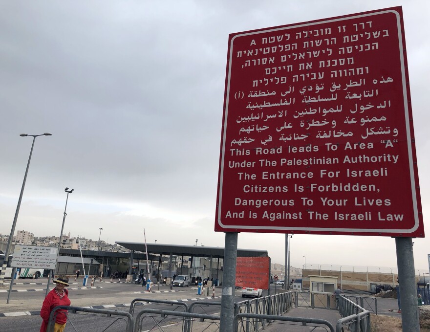A sign at an Israeli checkpoint warns Israelis not to enter. A Palestinian neighborhood is located behind the checkpoint.