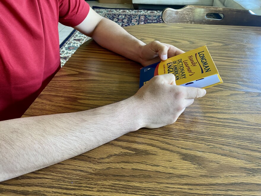 Mirzaye holds his English language dictionary in his hands. He's one of 150 refugees who moved to Sioux City from Tyson for work.