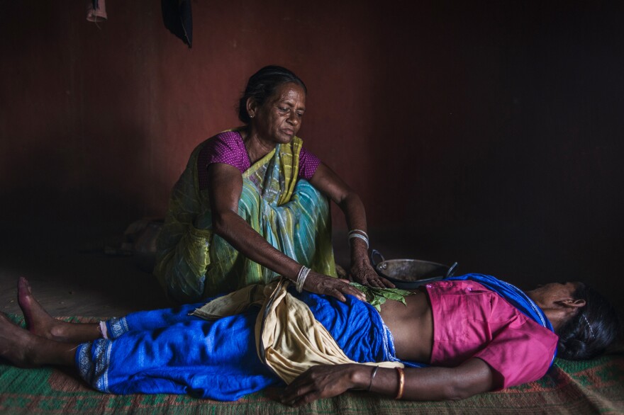 Sonpati, 55, a midwife in Salihatu Village, uses warm herbs and sand to massage the belly — her method of carrying out an abortion and also treating abdominal pain.