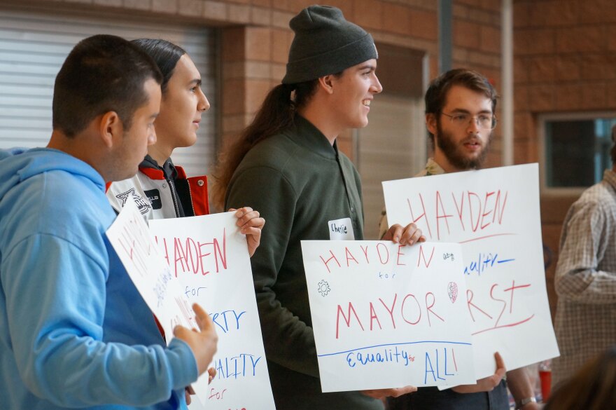 Students Mateo Peterson, second from left, and Charlie Matheson, third from left, hold signs supporting Teal Party candidate Hayden Wilson, right, Jan. 6, 2024.