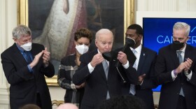 President Joe Biden replaces his protective mask after speaking during a "Cancer Moonshot," event in the East Room of the White House, Wednesday, Feb. 2, 2022, in Washington. (AP Photo/Alex Brandon)