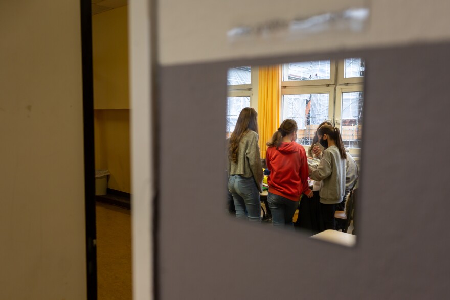 Students working on a book project at the Fritz-Karsen-Shule in Berlin are reflected in a mirror on the classroom wall.