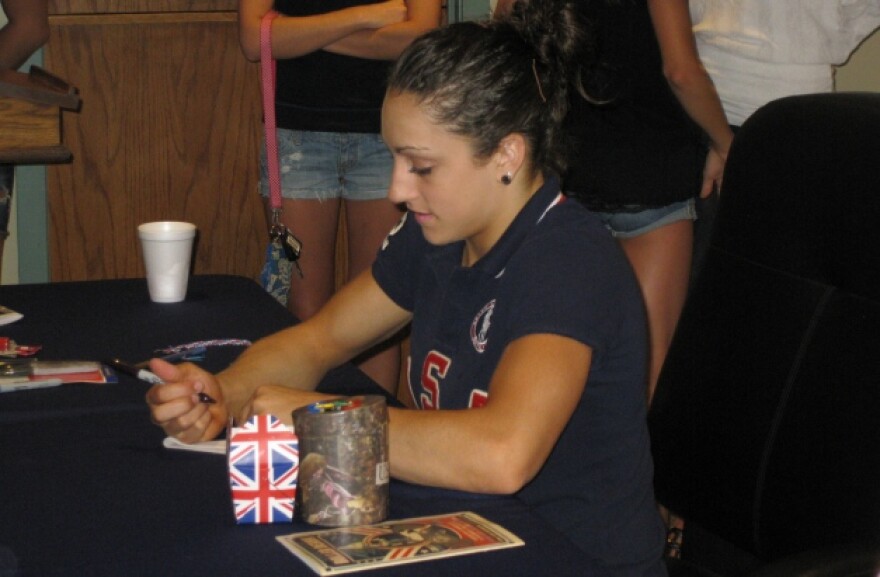 Gymnast Jordyn Wieber signs an autograph for a fan at a fundraiser to help her family attend the Olympic Games in London.