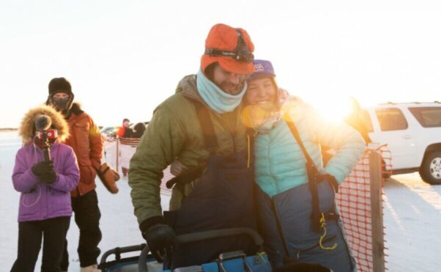 Two mushers side hug outside