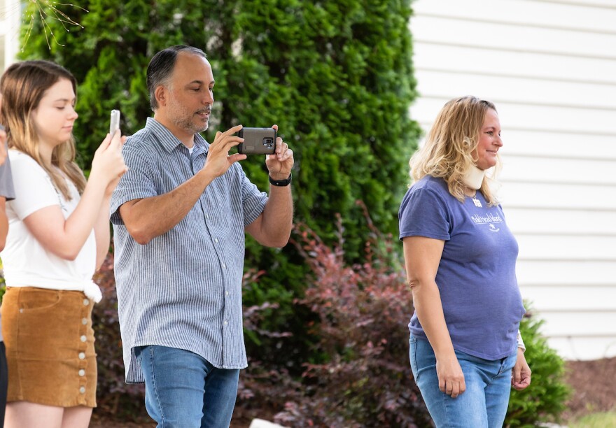 Eric August, middle, and Sherry August, right, watch their triplet daughters enjoy a surprise musical performance on the morning of their sixteenth birthday by Paula Snyder at their home in Raleigh, N.C. on Thursday, May 14, 2020.