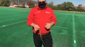 Commander of the Cincinnati Police Academy Lt. Joe Richardson holds the remains of the kevlar cord after being "wrapped up" by WVXU's Ann Thompson who tried out the BolaWrap.