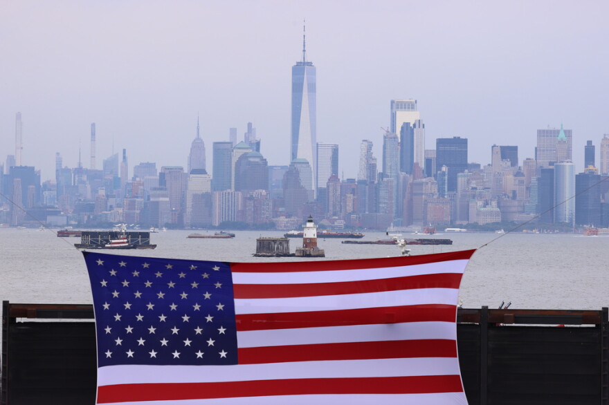 An American flag hangs in front of lower Manhatten in New York.