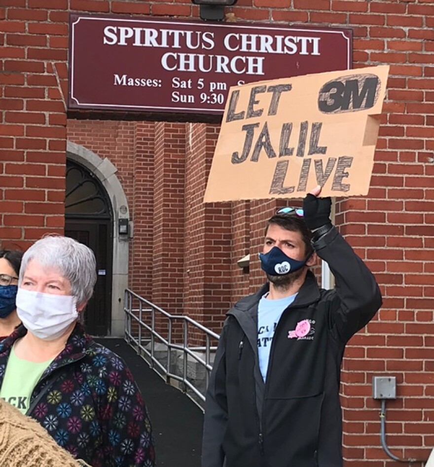 A supporter of Jalil Muntaqim holds aloft a sign Thursday at a rally calling for authorities to drop the voter fraud charges against Muntaqim.