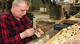 David Reisenleiter glues wooden plugs into the bottom of the section of cob that will form the bowls of corn cob pipes at the Missouri Meerschaum Company in Washington, Missouri.