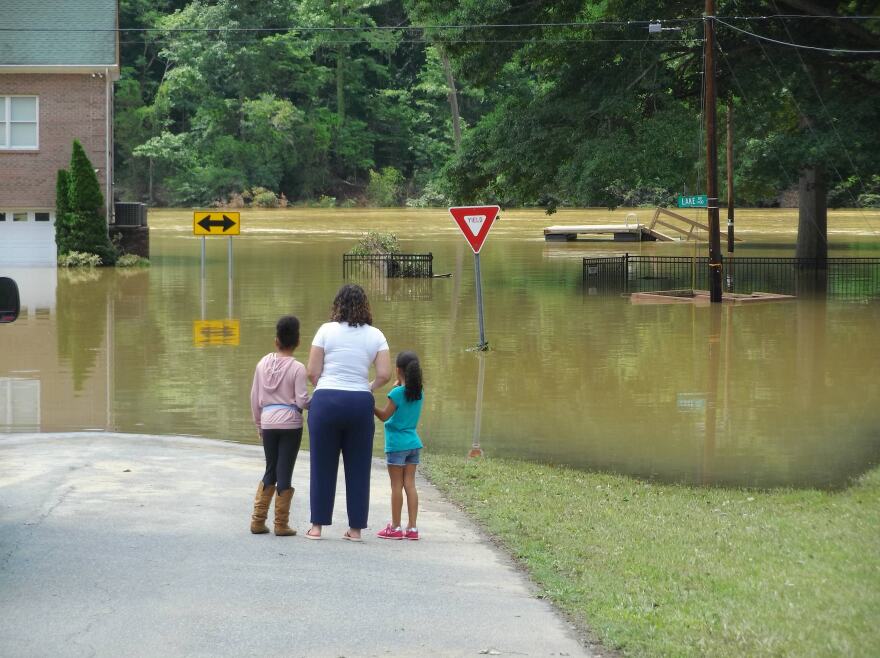 A family walked down Riverside Dr. to look at the flooding on May 10, 2019.