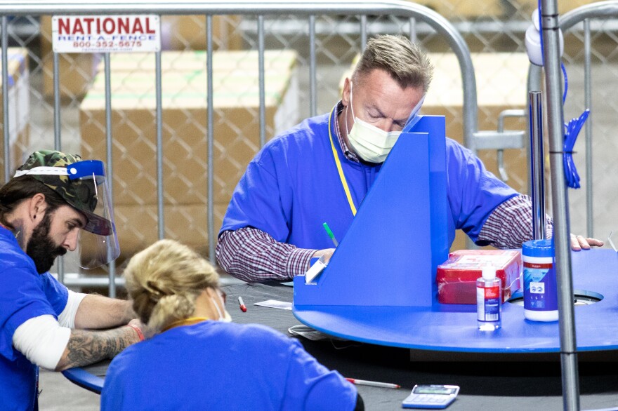 Contractors working for the firm Cyber Ninjas, which was hired by the Republican-led Arizona state Senate, count Maricopa County ballots from the 2020 general election at Veterans Memorial Coliseum on Saturday in Phoenix.