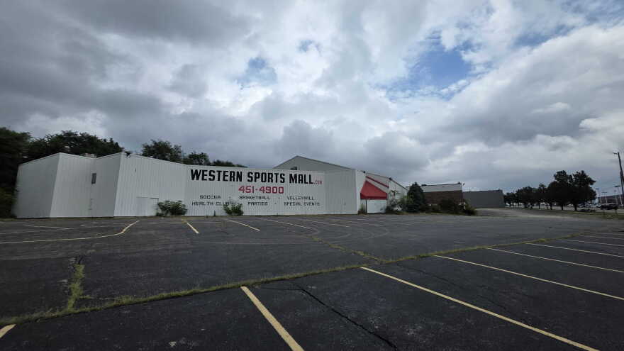 A large building with the words Western Sports Mall in front of a large parking lot.